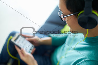 Asian Man With Green Headphones Listens Music Podcast Phone