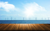 3D background of a wooden table looking out to a wind farm in th