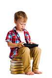 boy with a Tablet PC sitting on the books