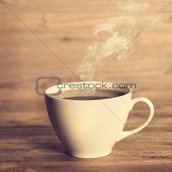 Steaming hot coffee in white cup