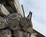 large concrete chunks with twisted metal and industrial building
