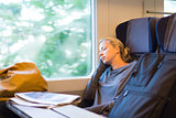 Lady traveling napping on a train.