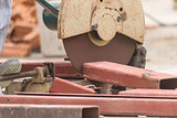 Worker cutting metal with grinder in construction site
