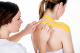 physiotherapist gets tapes on the trapezius
