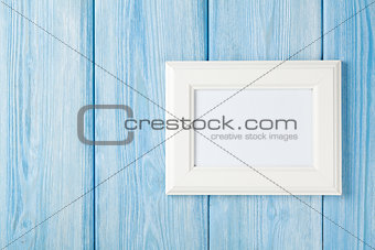 Photo frame on blue wooden wall