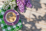 Coffee cup and colorful lilac flowers on garden table