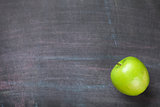 Green apple on blackboard or chalkboard background