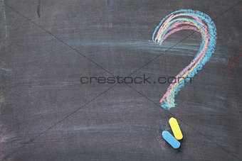 Colorful chalk question mark on blackboard background
