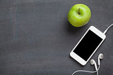 Smartphone and apple on blackboard background