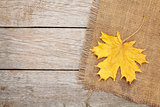 Autumn maple leaves over burlap texture background