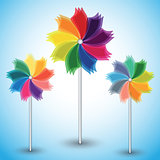 Three colorful windmills on blue background. 