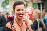 Attractive woman holding a red caramelized apple at the Oktoberfest