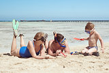 Parents and child in snorkels playing on the beach