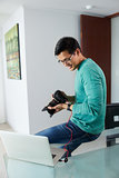 Asian Man Tethering DSLR To Laptop PC Downloading Photo