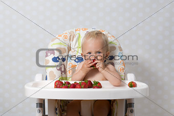 Baby girl eating strawberries