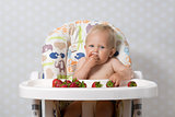 Baby girl eating strawberries