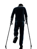 injured man walking with crutches silhouette rear view