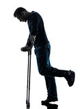 injured man walking sad with crutches silhouette