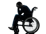 handicapped man head in hands in wheelchair silhouette