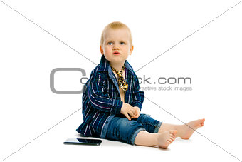 boy in a tie sitting on a white floor
