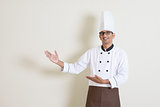 Indian male chef in uniform showing something