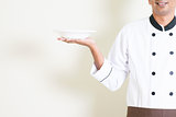 Indian male chef in uniform holding an empty plate