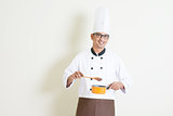 Indian male chef in uniform cooking