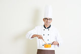 Indian male chef in uniform cooking food