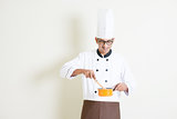 Indian male chef in uniform preparing food