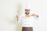 Indian male chef in uniform cooking and enjoy the food aroma