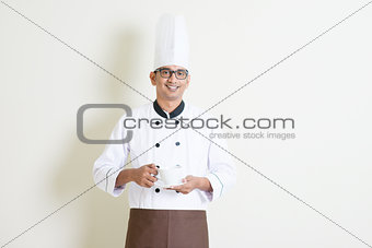 Indian male chef in uniform holding a coffee cup