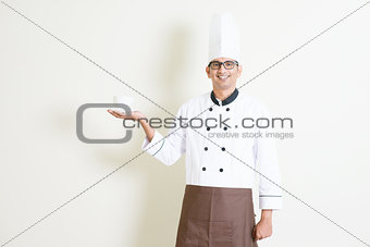 Indian male chef in uniform presenting a coffee cup