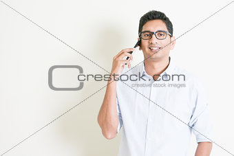 Casual business Indian male calling on smartphone