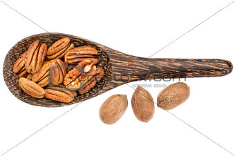 pecan nuts on wooden spoon