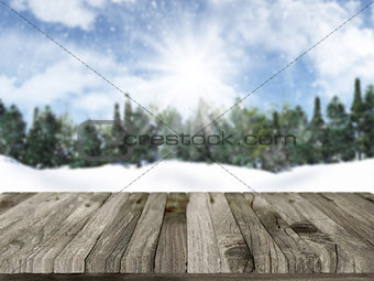 Wooden table with defocussed christmas snowy landscape in the ba