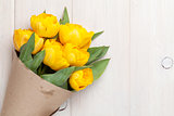 Yellow tulips over wooden table