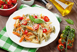 Colorful penne pasta with tomatoes and basil