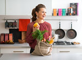Laughing woman in profile, fall fruit and vegetables in kitchen