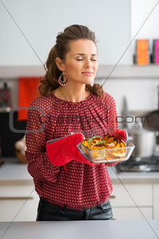 Woman cook in kitchen enjoying the smell of roasted pumpkin