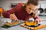 Elegant woman leaning over dish as she is serving pumpkin