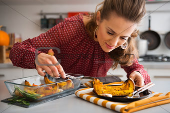 Elegant woman leaning over dish as she is serving pumpkin