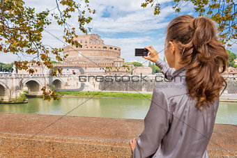 Woman from behind taking photo of Castel St'Angelo in Rome