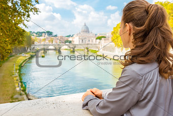Elegant woman looking out onto Tiber River in Rome