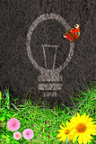 Eco background with green grass and light bulb silhouette 