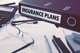 Insurance Plans on Ring Binder. Blured, Toned Image.