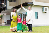 Asian Indian family outside their new home