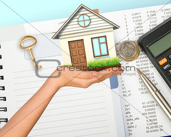 Humans hand holding house with key and calculator
