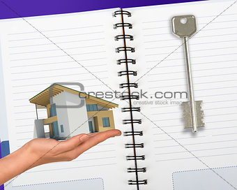 Humans hand holding house with key