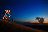 biker and bicycle on sunset background.