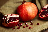 Raw red pomegranate with seeds on sacking